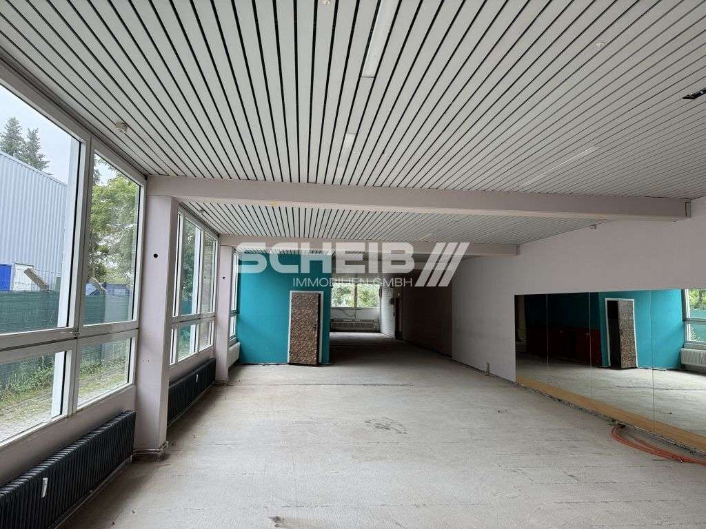 Halle mit Rolltor, Tageslicht und Parkplätzen